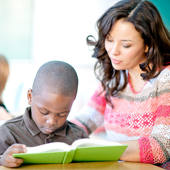 Student and teacher reading book.